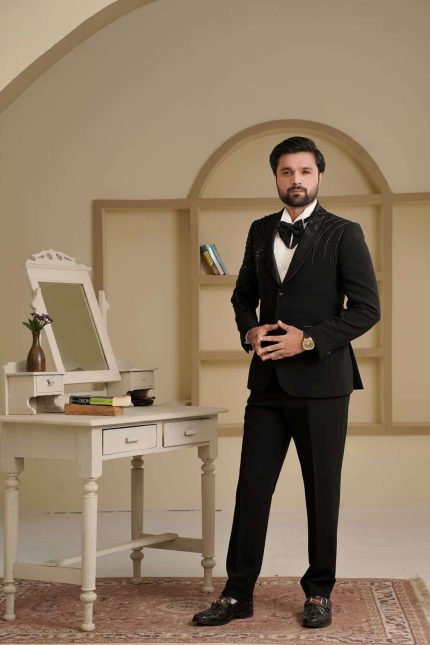 Groom wearing black two piece suit with handmade embroidery