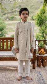 Boy wearing an elegant ivory embroidered Korean silk kurta pajama on a wooden terrace.